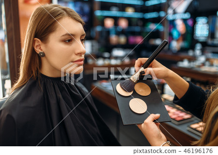 Visagiste applies powder, woman in makeup shop 46196176