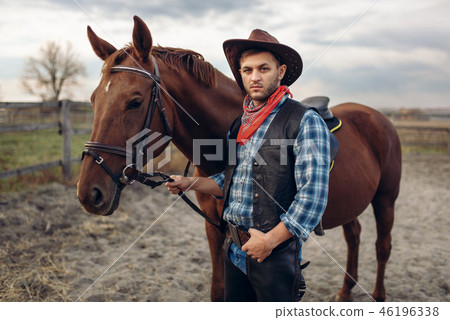 Cowboy poses with horse on texas farm Cowboy poses with horse on texas farm 46196338