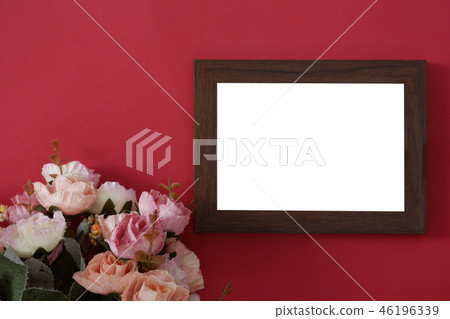 empty photo frame on red background and flowers 46196339