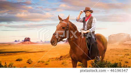 Cowboy riding a horse in desert valley, western 46196347