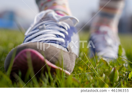 The girl is walking along the green grass The girl is walking along the green grass 46196355