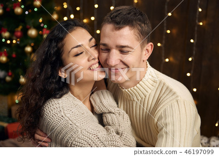 young couple is in christmas decoration and lights young couple is in christmas decoration and lights 46197099