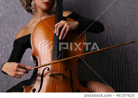 female hands with a bow on cello strings 46197620
