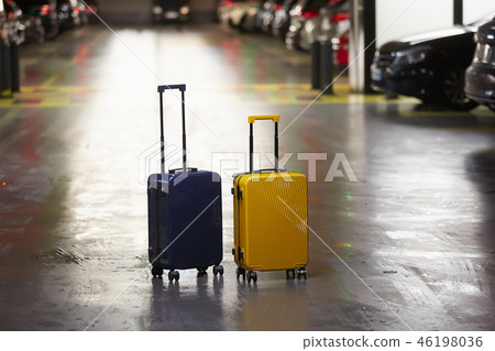 Luggage bag on the city street ready to pick by airport transfer taxi car. 46198036