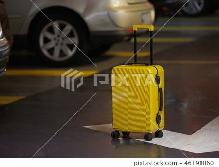 Orange suitcase on the road in city. Summer vacation and travel concept 46198060