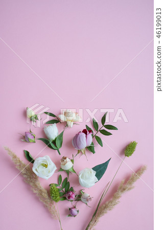 Frame of purple and pink roses, white Lisianthus and different flowers on pink background. 46199013