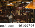Wooden tables and chairs in the cafe. It's dark. 46199796