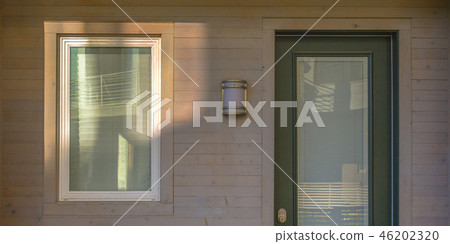Glass paned green door and glass window of home Glass paned green door and glass window of home 46202320