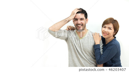 Happy young Couple standing over white wall. Happy young Couple standing over white wall. 46203407
