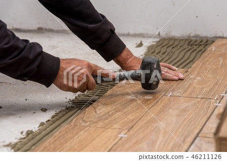 Worker placing ceramic floor. 46211126