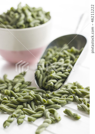 Uncooked spinach gemelli pasta. 46211222