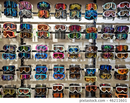 Sport equipment background. Colored snowboard masks in a rows on a showcase. Colorful ski masks on 46211601