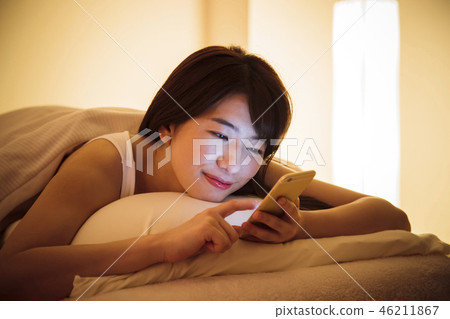 Woman sleep smart phone bedtime young woman cute lifestyle 46211867