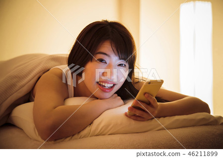 Woman sleep smart phone bedtime young woman cute lifestyle 46211899