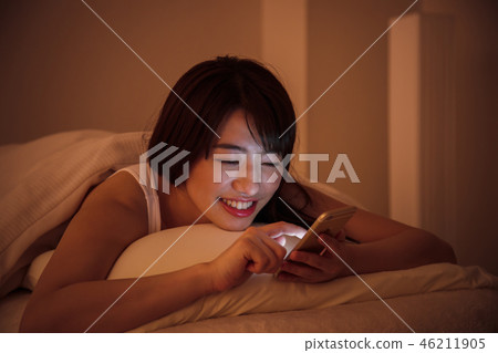 Woman sleep smart phone bedtime young woman cute lifestyle 46211905