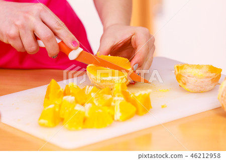 Woman housewife in kitchen cutting orange fruits Woman housewife in kitchen cutting orange fruits 46212958