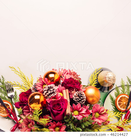 Christmas table setting decorated with bouquet of flowers, sprigs of thuja and dry oranges Christmas table setting decorated with bouquet of flowers, sprigs of thuja and dry oranges 46214427