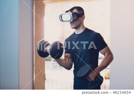 Man wearing virtual reality glasses with dumbbells 46214854