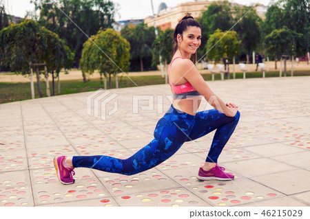 Runner fit woman warming up before sport training in the park 46215029