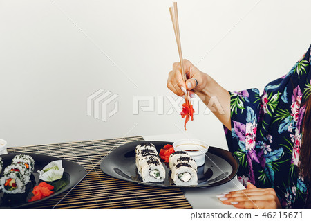 Beautiful girl eating a sushi in a studio 46215671