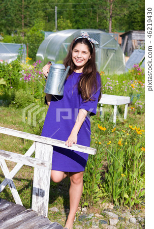 Girl with water can in garden Girl with water can in garden 46219430
