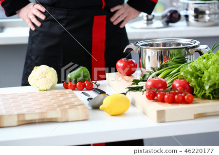 The cook in the kitchen is preparing 46220177