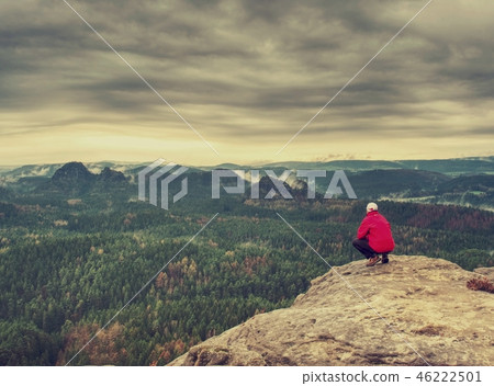 Cold misty day on trail. Man take moment on cliff  46222501