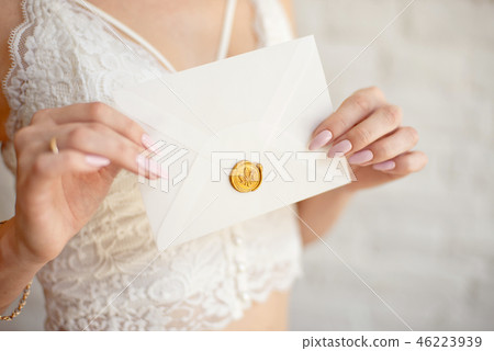 Closeup woman with slim body in lace underwear holding invitation card in hand, back view Closeup woman with slim body in lace underwear holding invitation card in hand, back view 46223939