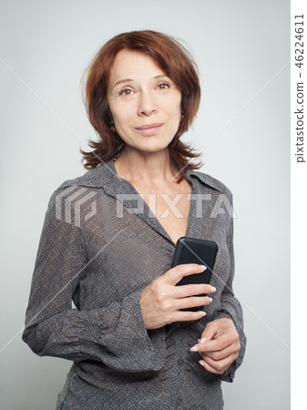 Mature woman with smartphone on white Mature woman with smartphone on white 46224611