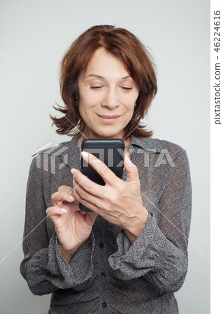 Mature woman texting on white background Mature woman texting on white background 46224616