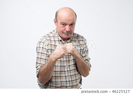 Man standing in boxer pose with raised fists Man standing in boxer pose with raised fists 46225527