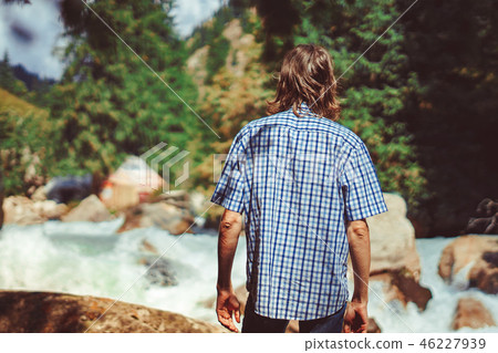 the guy stands at the mountain river 46227939