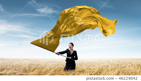 Woman waving yellow flag Woman waving yellow flag 46229042