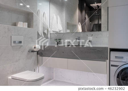 Illuminated modern bathroom with tiled walls and floor 46232902
