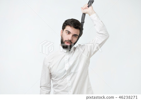 man in white shirt strangling himself tie. man in white shirt strangling himself tie. 46238271