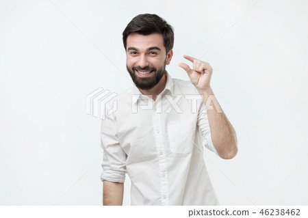 Handsome hispanic man showing something little Handsome hispanic man showing something little 46238462