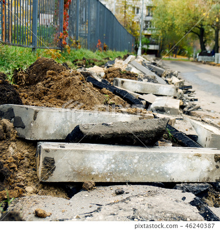 Broken freshly dug up old curbstones with pieces of an asphalt and earth lying on the road in Moscow Broken freshly dug up old curbstones with pieces of an asphalt and earth lying on the road in Moscow 46240387