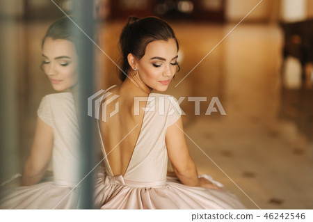 Beautiful stunning young lady in amazing dress sitting on luxury armchair Beautiful stunning young lady in amazing dress sitting on luxury armchair 46242546