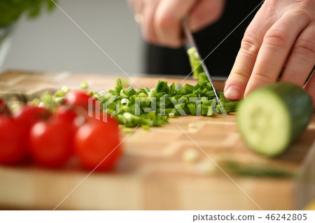 Cook holds knife in hand and cuts on Cook holds knife in hand and cuts on 46242805