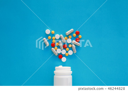 Pills heart out of pill bottle on blue background. Pills heart out of pill bottle on blue background. 46244828