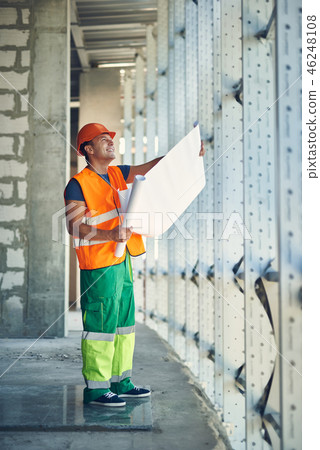 Builder standing with his drawing and smiling Builder standing with his drawing and smiling 46248108