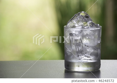 Ice cube in the glass on table with nature Ice cube in the glass on table with nature 46248572