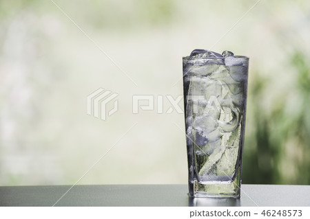 Ice cube and water in the glass on table Ice cube and water in the glass on table 46248573