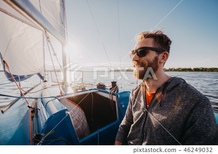 Successful young bearded man sailing portrait at sunrise on boat 46249032