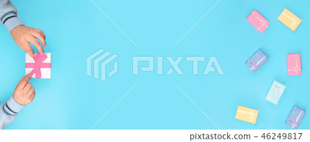 Top view of hands holding small box. Top view of hands holding small box. 46249817