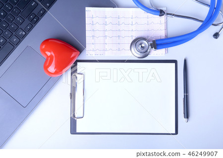 Workplace of doctor with laptop, stethoscope, red heart and RX prescription on white table. top view Workplace of doctor with laptop, stethoscope, red heart and RX prescription on white table. top view 46249907
