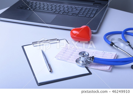 Workplace of doctor with laptop, stethoscope, red heart and RX prescription on white table. top view Workplace of doctor with laptop, stethoscope, red heart and RX prescription on white table. top view 46249910