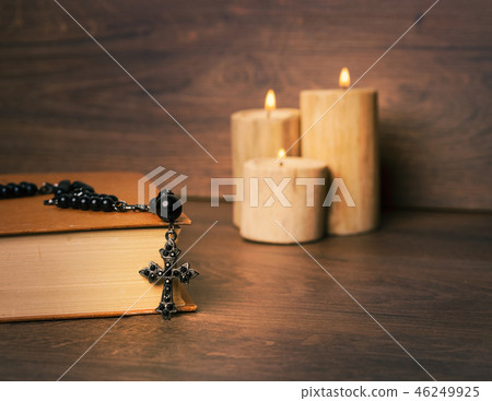 Black rosary and candle at wooden table Black rosary and candle at wooden table 46249925