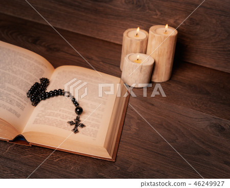 Black rosary and candle on the bibble Black rosary and candle on the bibble 46249927