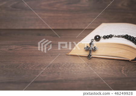 Black rosary on the Bible at wooden table Black rosary on the Bible at wooden table 46249928